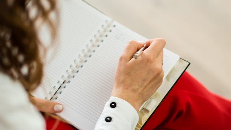 woman in red blazer holding white paper